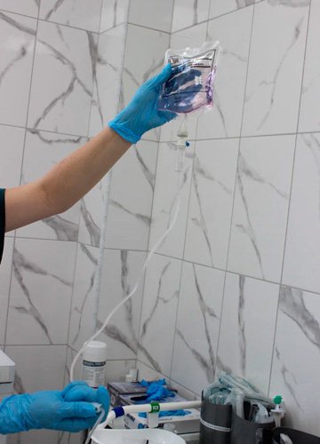 Врач поправляет капельницу